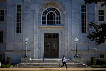 student walking past the entrance of the Candler Library